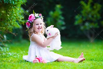 Cute girl playing with real bunny