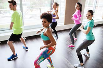 Group of smiling people dancing in gym or studio