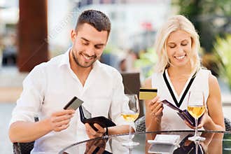 Couple with credit cards paying bill at restaurant