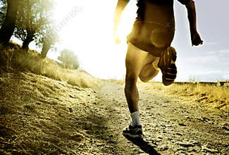 Legs and feet extreme cross country man running training at countryside sunset