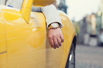 Man hand with golden watch in car