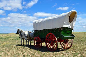 A conestoga wagon pulled by team of horses