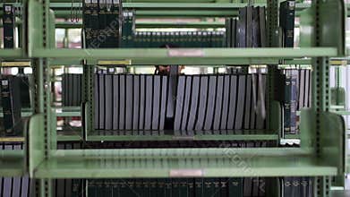 Video of Female, girl student walking between shelves, searching for books in library