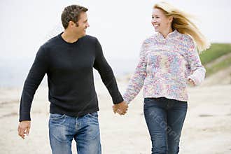 Couple walking at beach holding hands