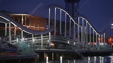 Night view of Rambla de Mar, footbridge modern design in the port of Barcelona.