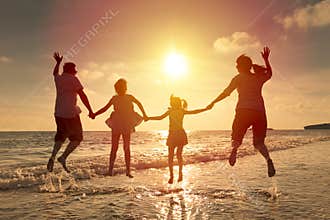Happy family jumping on the beach