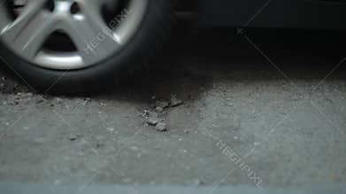 Car driving through pot hole