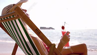 Pretty girl enjoying a cocktail in the deck chair