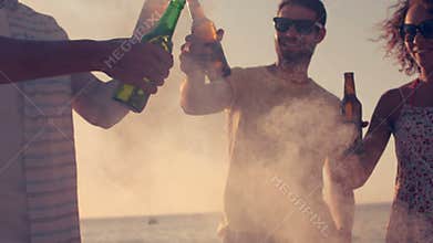 Happy friends toasting beers on the beach