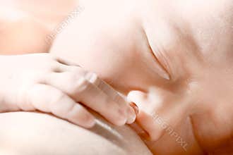 Newborn baby eating breast-milk