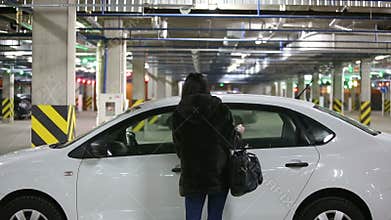 Girl in the underground garage sits in the car