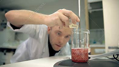 The laboratorian is adding an ingredient into personal care products