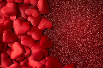 Little red satin hearts on red glitter texture, valentines or mothers day background