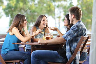 Group of friends talking and drinking at home