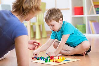 Mother and her son playing in board game