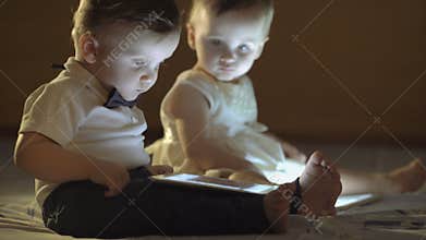Two children playing with a tablet