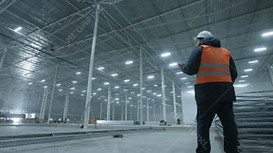 Engineer talking on the phone in new modern industry warehouse