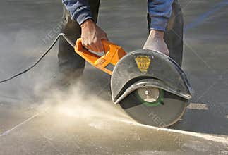 Man cutting groove in concrete slab