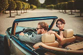 Wealthy couple in classic convertible