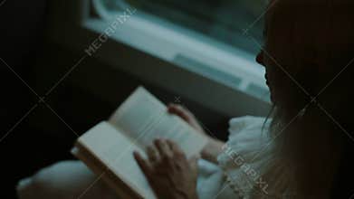 Blonde reading a book in the train