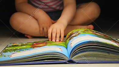 Child flipping book. Children's book with colorful pictures
