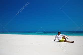 Freedom. Beach. Handsome man in hat resting on exotic seashore w