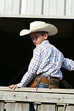 Young cowboy on fence