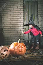 Little witch making a magic potion at Halloween night. Horror.