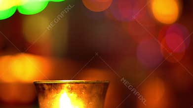 Candle in a glass stay on wooden table in blues music bar. Blurred backround. Bokeh. Colored illumination. 4K