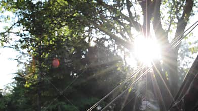 A tranquil camping scene, with campfire smoke in suns rays through trees
