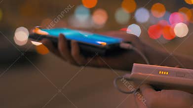 Woman charging smart phone with power bank