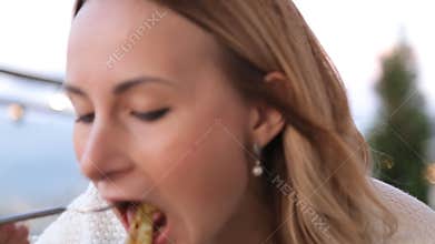 Young woman eating spaghetti in cafe