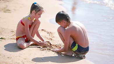 Children. boy and girl playing with sand on the beach. build a sand castle