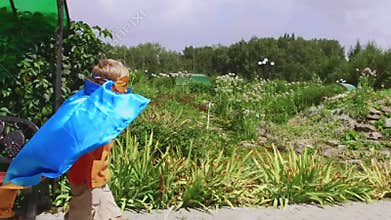 Young boy dressed as superhero playing outdoors