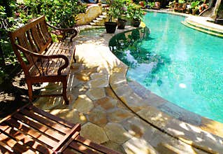 Sunny outdoor swimming pool and patio furniture