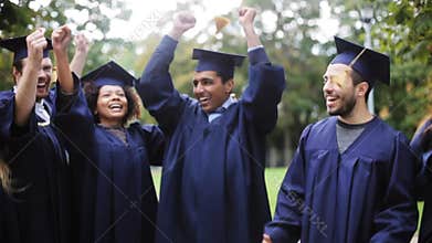 Happy students in mortar boards with diplomas