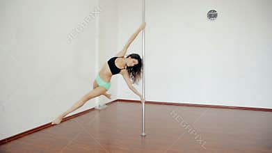 Wide shot Young girl dancing poledance in white room