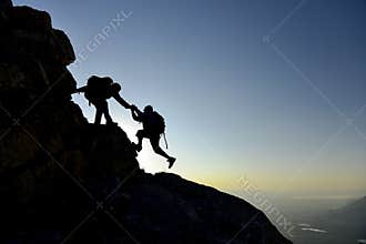 Climber helping friend on mountainside