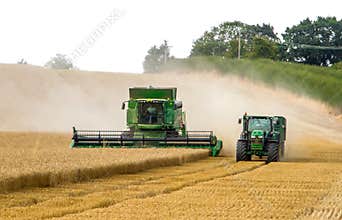 Modern 9780i cts john deere combine harvester cutting crops corn wheat barley working golden field