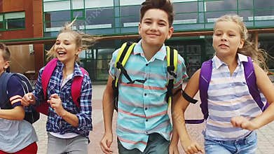 Group of happy elementary school students running