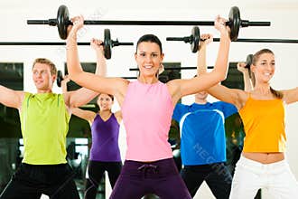 Fitness group with barbell in gym