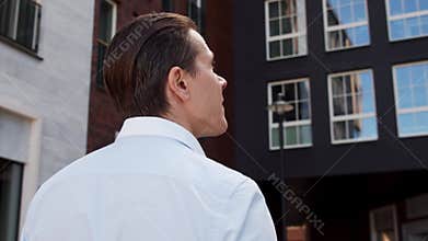 Young and attractive freelancer walking outdoor. Office worker or businessperson. Business and real estate.