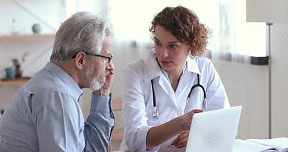 Focused old man listening to cardiologist at checkup meeting.