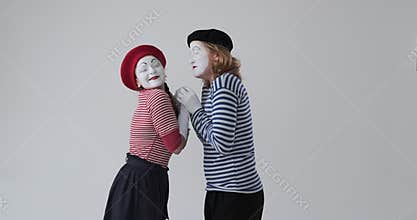Excited mime couple running to each other and embracing