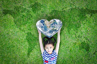 World heart day concept and well being health care campaign with smiling happy kid on eco friendly green lawn.