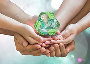 World environment day and ecology concept with family`s hands saving green planet with recycle sign.