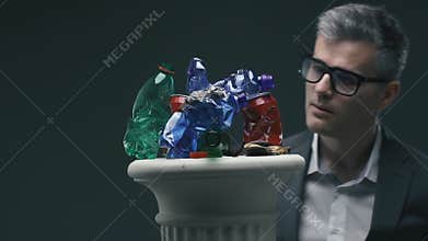 Man watching contemporary trash art on a pedestal