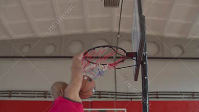 Black basketball player performing slam dunk