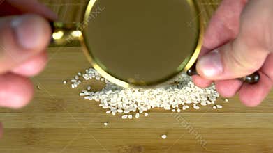 Rice increase grits under a large glass of spoon on a board with a brown background
