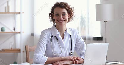 Portrait of smiling 30s female doctor in white medical coat.
